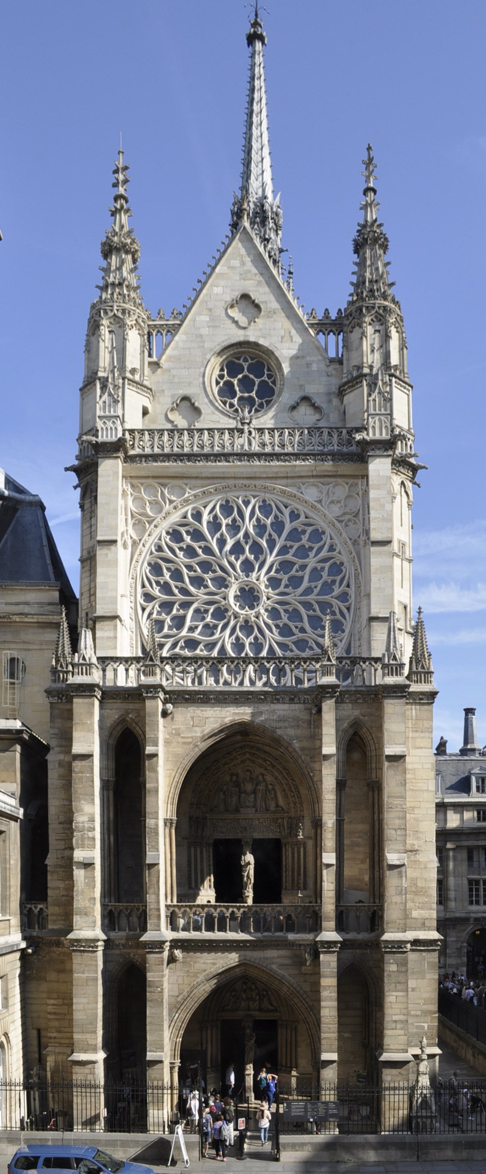 Façade ouest de la Sainte-Chapelle vue depuis le Palais de Justice : rosace, porche, visiteur et voiture.